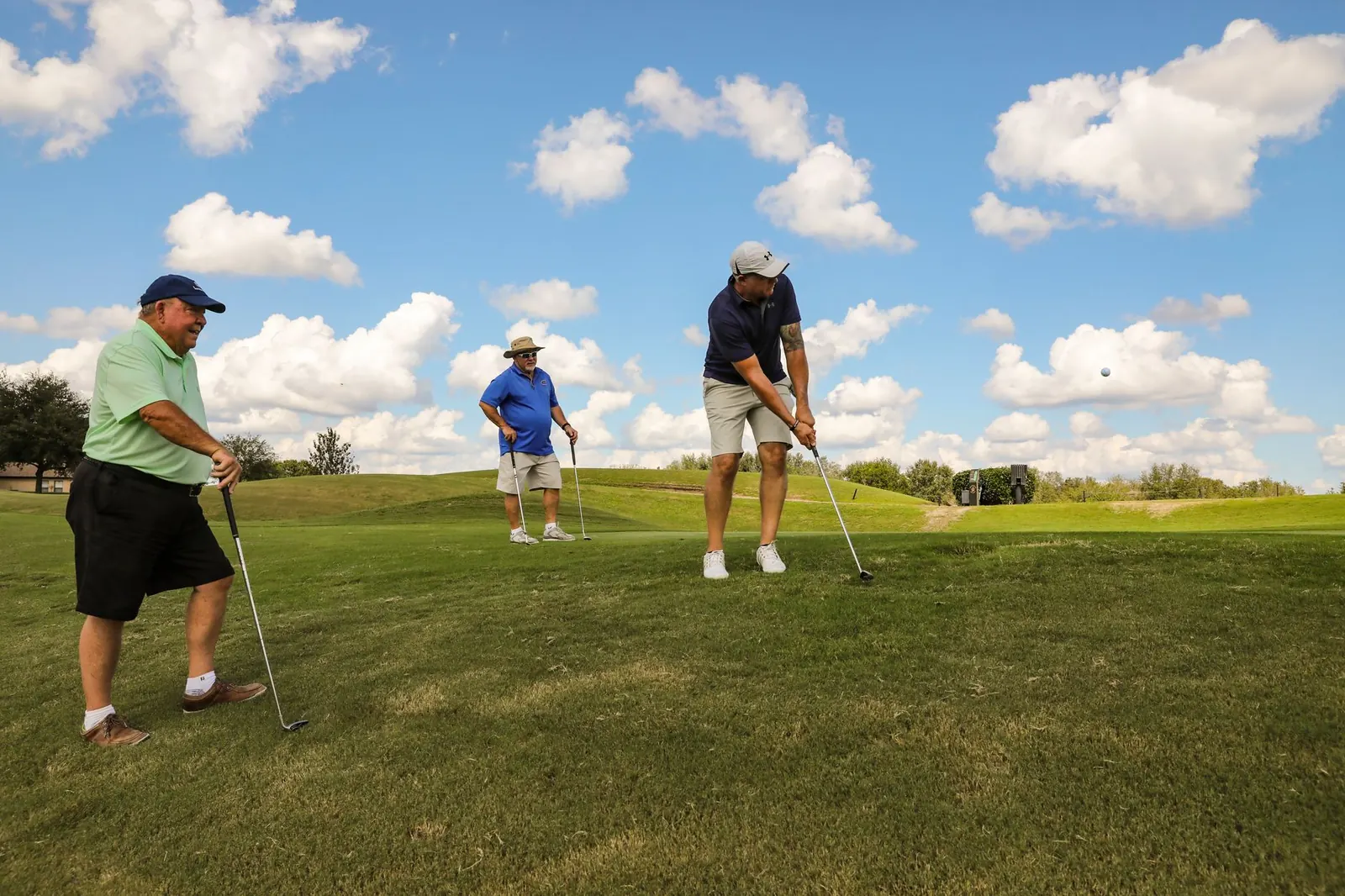 A group of adult golfers playing together on a fairway